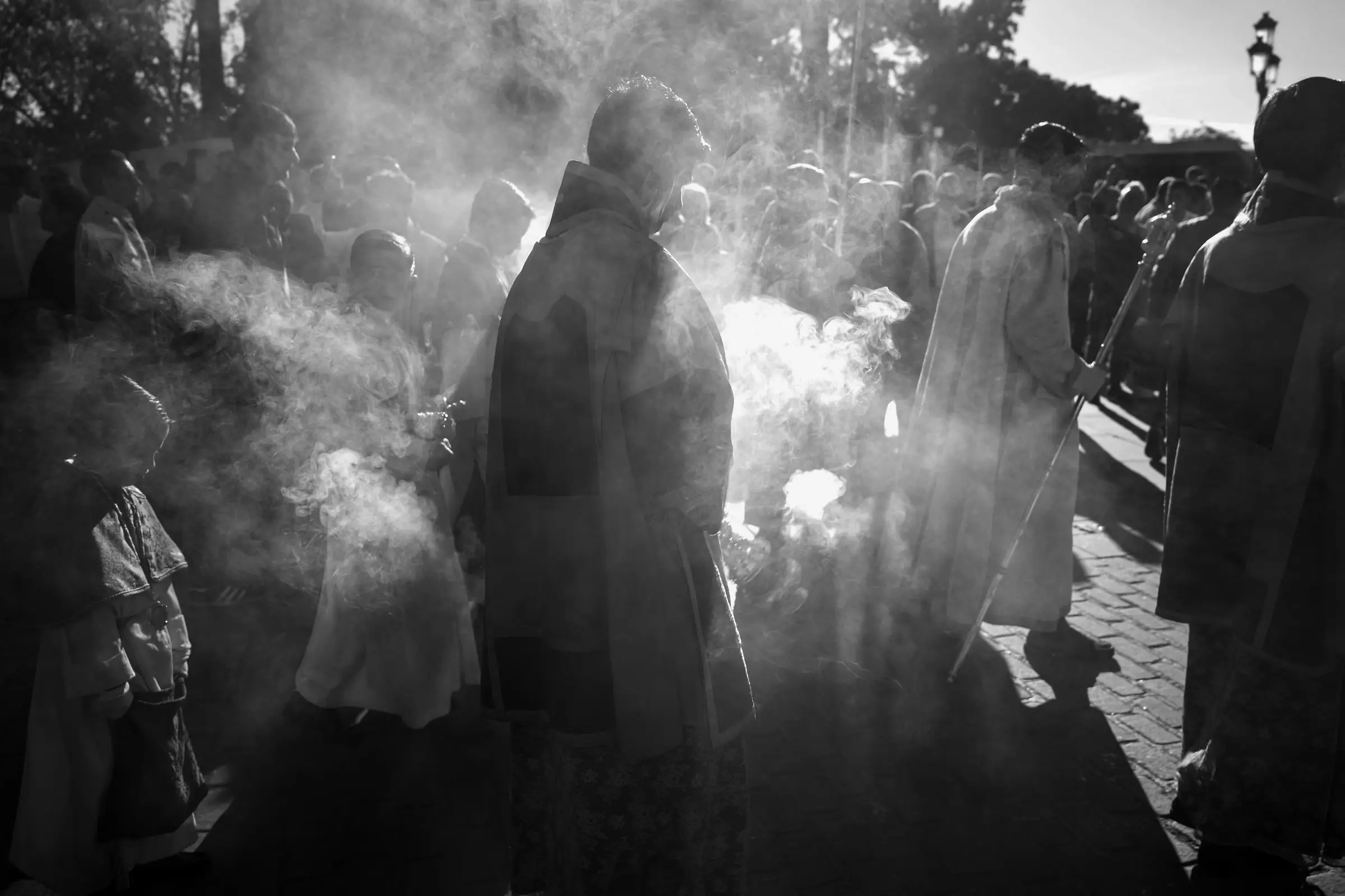 Fotografía de calle en blanco y negro: gente entre el humo del incienso